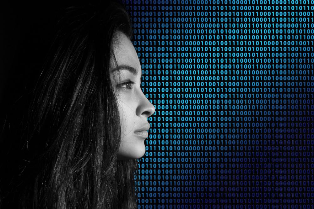 Side profile of a woman in front of a background of binary code.