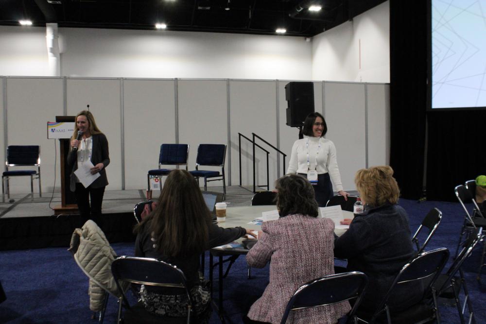 Amanda Shores standing at a white round table during her session at the 2024 AAAS Annual Meeting.