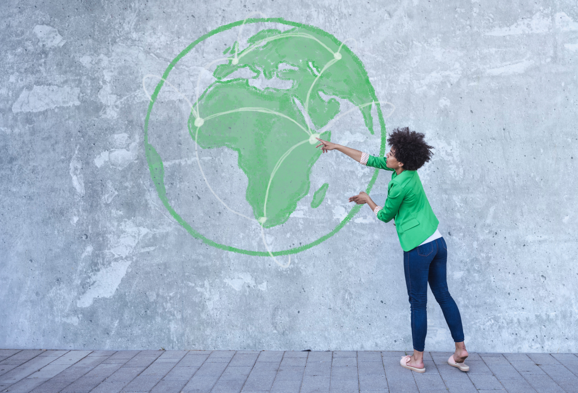 Woman pointing at the world map on the wall.