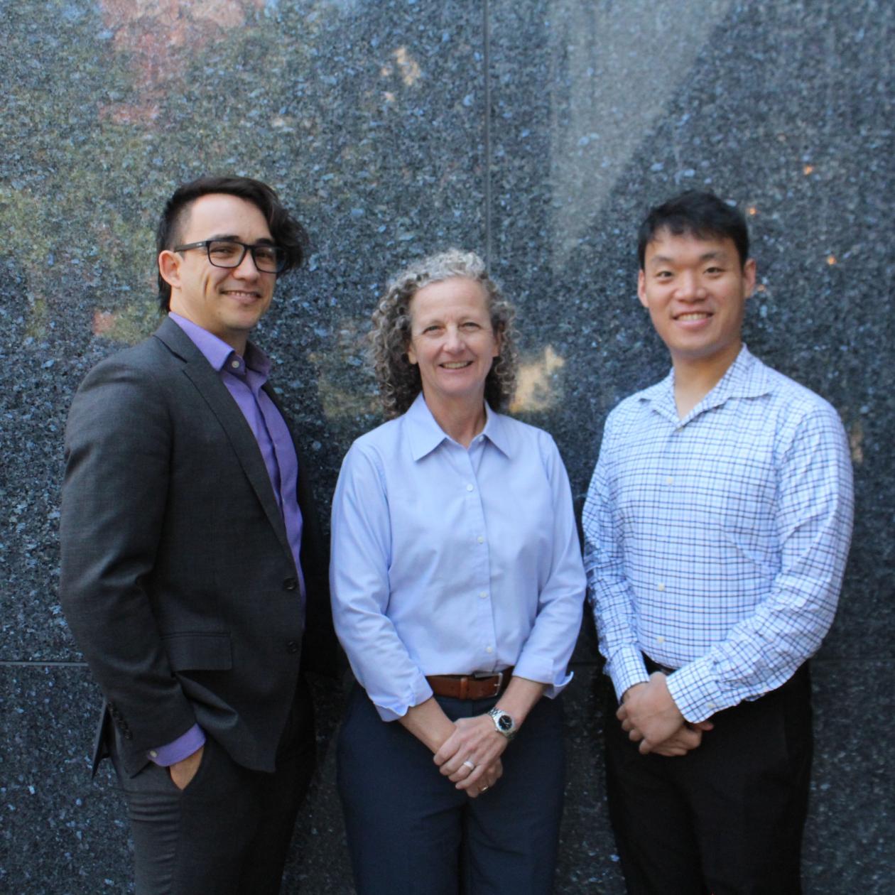 From left to right: Incoming STPF Fellows Ricardo Millan, Caroline Clevenger and Timothy Chu pose in front of a grey stone wall.