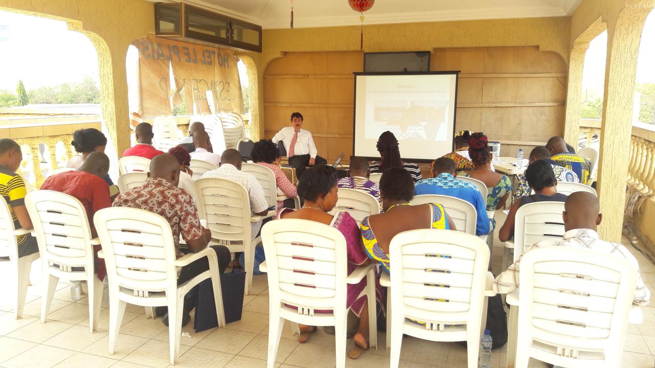 People sitting in a classroom, listening to a presentation. By International Narcotics and Law Enforcement Affairs, U.S. Department of State