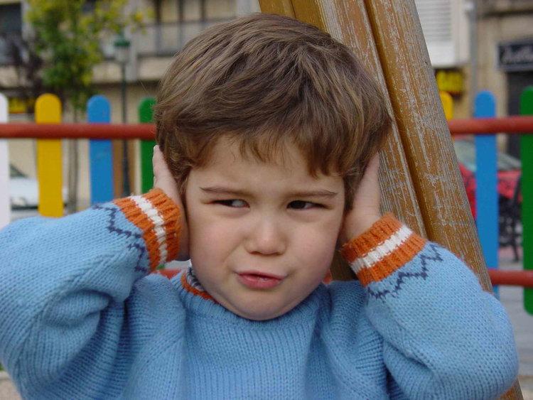 A child clamping his hands over his ears.