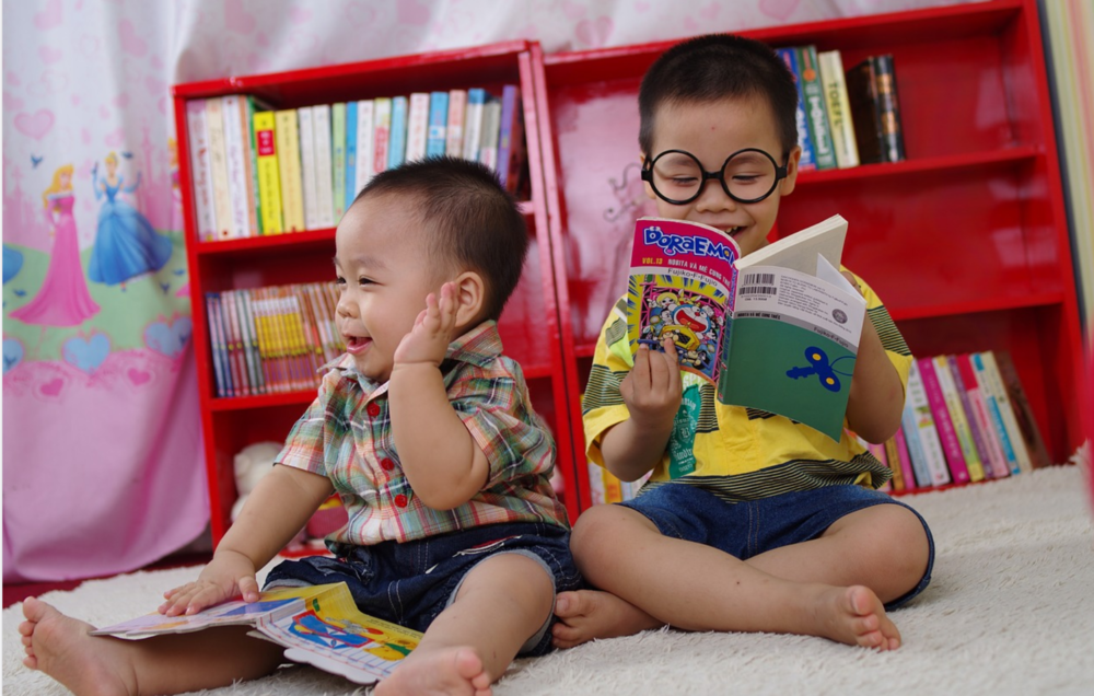 Two young children reading books.