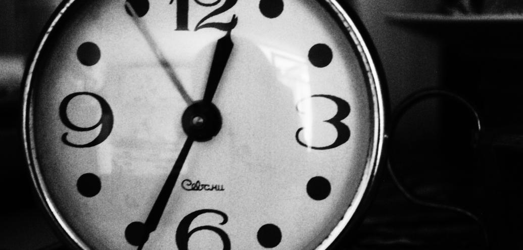 Close up photo of a black and white clock. By Unsplash.