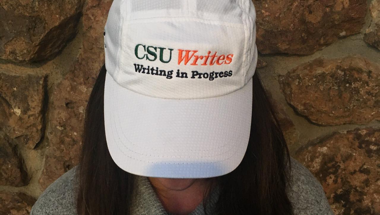 Woman wearing a white CSU Writes cap.