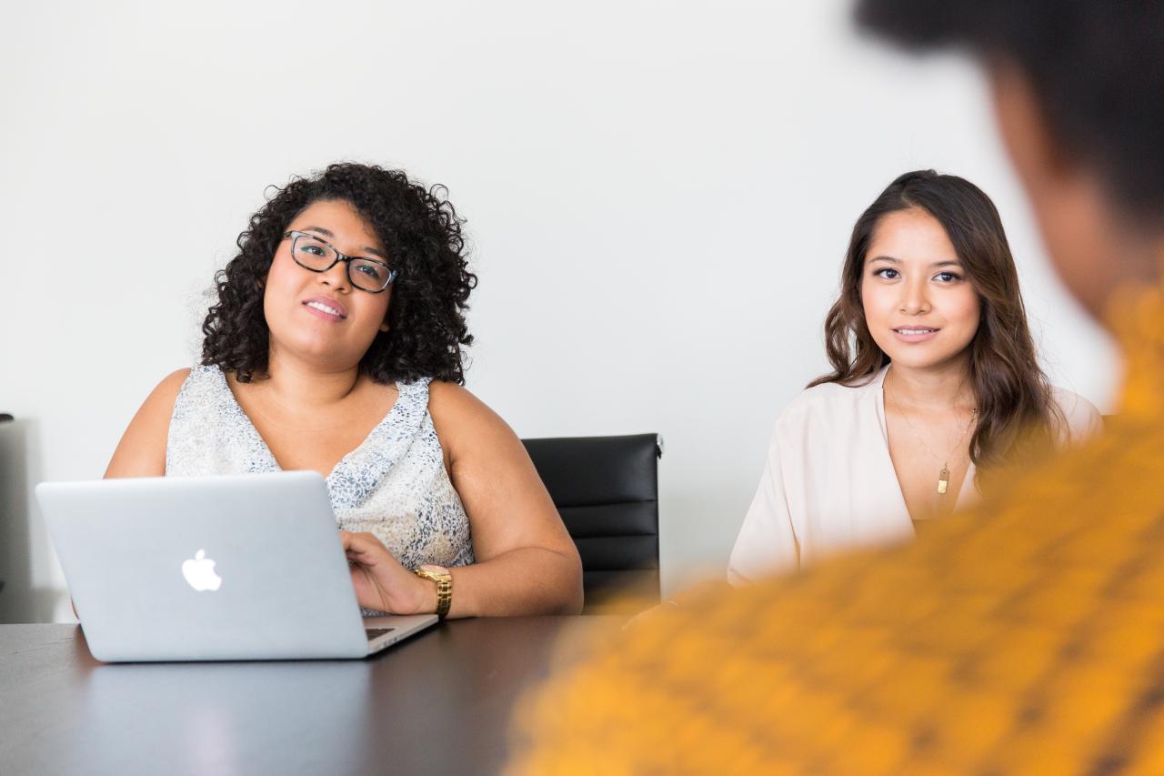 Two women sitting at a conference table, by Christina Wocintechchat, Unsplash