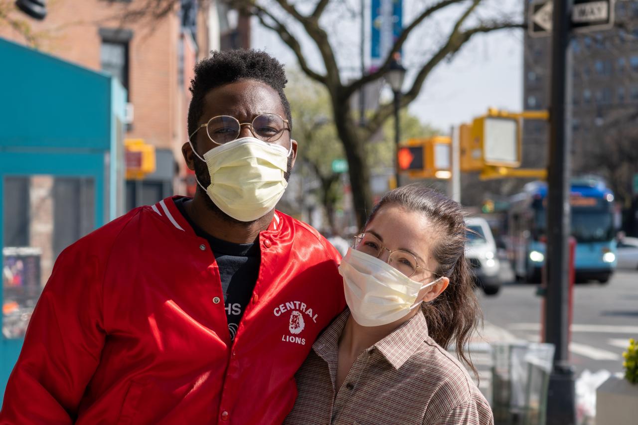 Two people wearing masks hugging and smiling at the camera, Julian Wan, Unsplash