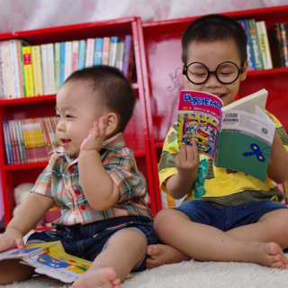 Two young children reading books.
