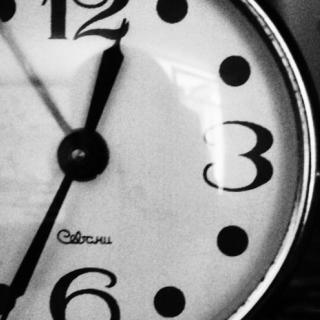 Close up photo of a black and white clock. By Unsplash.