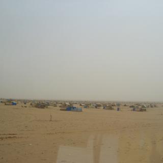 Dozens of tents in a desert. By Patrick Christian.