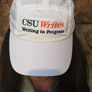 Woman wearing a white CSU Writes cap.