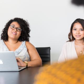 Two women sitting at a conference table, by Christina Wocintechchat, Unsplash