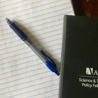 A blank notepad and pen, with an AAAS STPF notebook in the corner