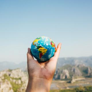Hand holding a globe by Porapak Apichodilok, Pexels