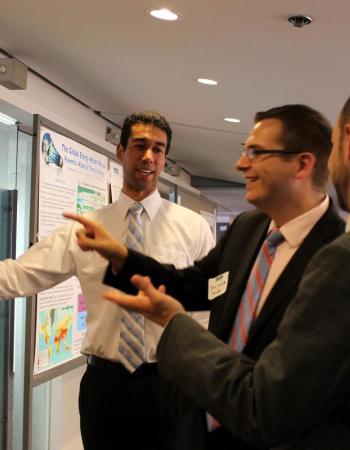 Fellows share and learn at a poster session. | Kat Song