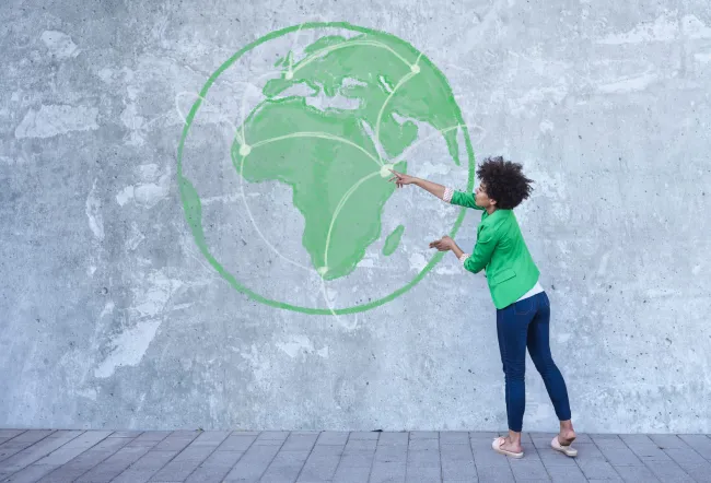 Woman pointing at the world map on the wall.